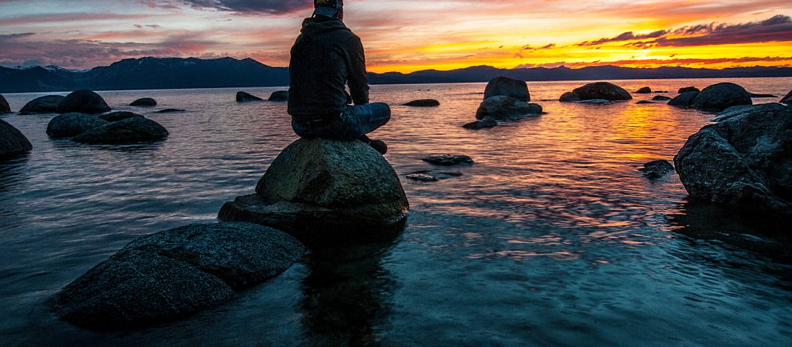person-sitting-on-rock-on-body-of-water-1478685